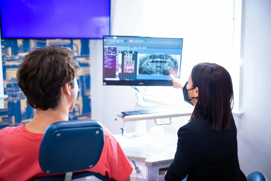 A dentist showing a patient his x-rays on the chairside monitor.