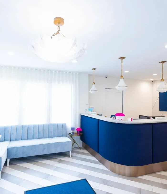The curved navy reception desk beneath three pendant lights.
